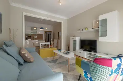 a living room with a blue couch and a tv at Two Bedroom Apartment Near to Doctors Garden in Sofia
