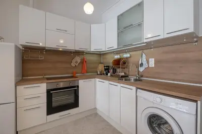 a kitchen with white cabinets and a washing machine at Two Bedroom Apartment Near to Doctors Garden in Sofia