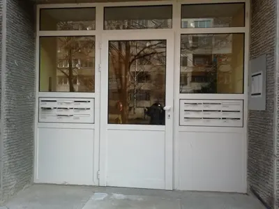 two doors on a building with a person in the reflection at Apartment Lagera 55 in Sofia
