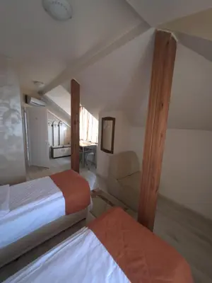a bedroom with two beds and a chair in a room at Hotel Orient in Blagoevgrad