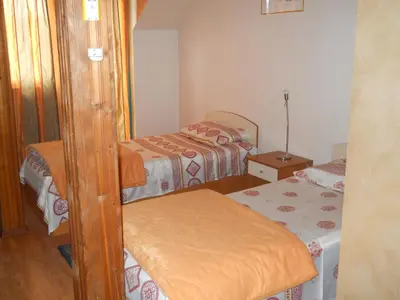 a small bedroom with two beds and a table at Hotel Orient in Blagoevgrad