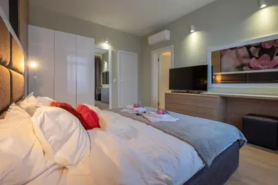 a bedroom with a large bed and a flat screen tv at Vitosha Blvd Luxury 2-Bedroom, 2-Bathroom with Balcony in Sofia