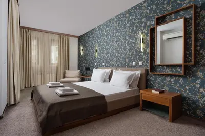 a bedroom with a large bed and a mirror at Boutique Hotel Uniqato in Bansko