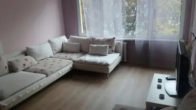 a living room with a white couch and a table at Cosy place close to the Center in Sofia