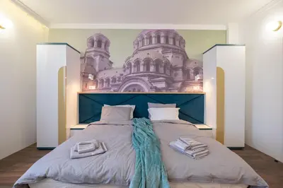 a bedroom with a large bed with a castle mural on the wall at Vitosha Blvd 3-Bedroom, 2-Bathroom Lux Suite in Sofia