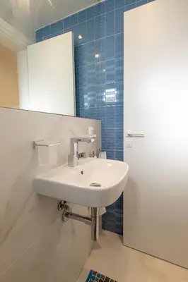 a bathroom with a white sink and a mirror at Vitosha Blvd 3-Bedroom, 2-Bathroom Lux Suite in Sofia