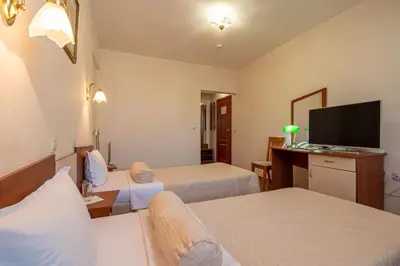 a hotel room with two beds and a flat screen tv at Primavera 2 Hotel in Pazardzhik