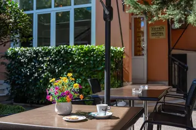 a table with a vase of flowers on it at Primavera 2 Hotel in Pazardzhik