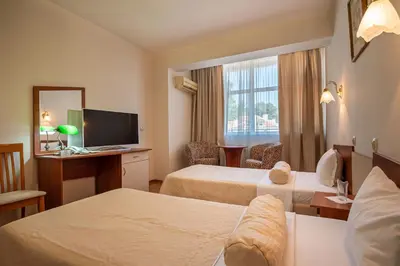 a hotel room with two beds and a television at Primavera 2 Hotel in Pazardzhik
