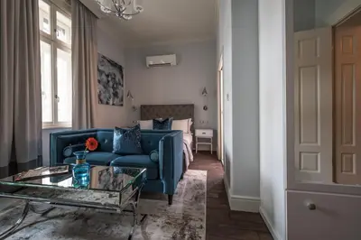 a living room with a blue couch and a table at 29A Guesthouse in Plovdiv