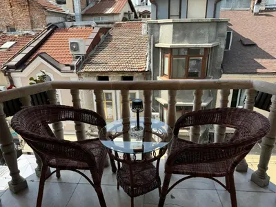 two chairs and a glass table on a balcony at Mini Hotel-Bohemi in Plovdiv