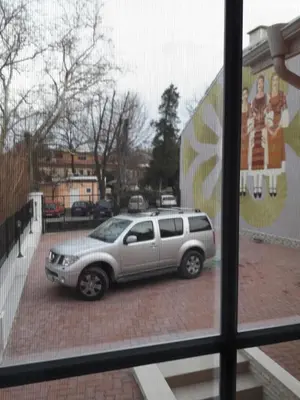 a silver suv parked in a parking lot through a window at Red House in Kyustendil