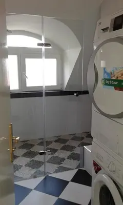 a bathroom with a washer and a checkered floor at Apartment Sagittarius in Kyustendil