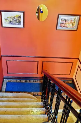 a set of stairs in a building with orange walls at L'Opera Guest House in Sofia