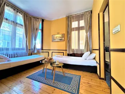 a hotel room with two beds and a table at L'Opera Guest House in Sofia