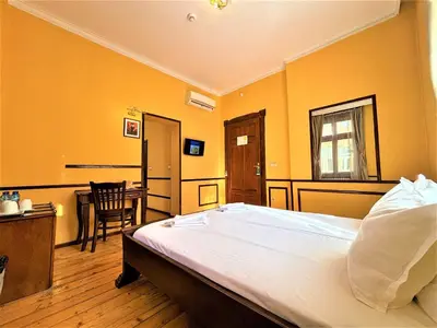 a bedroom with a large bed and a table at L'Opera Guest House in Sofia