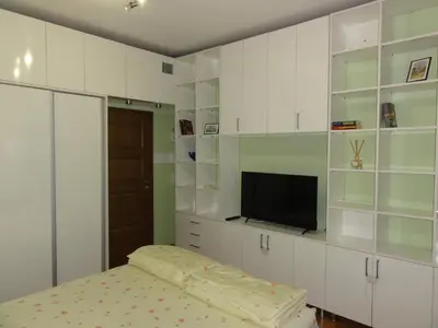 a bedroom with white cabinets and a flat screen tv at Apartment SOFIA LUX TOP CENTER in Sofia