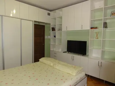a bedroom with white cabinets and a bed and a tv at Apartment SOFIA LUX TOP CENTER in Sofia