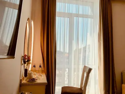 a room with a window with a chair and a table at ATLAS HOUSE Luxury Suites in Plovdiv