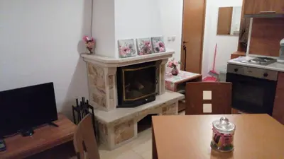 a living room with a fireplace and a table at Grand Monastery - Studio Rossa in Pamporovo