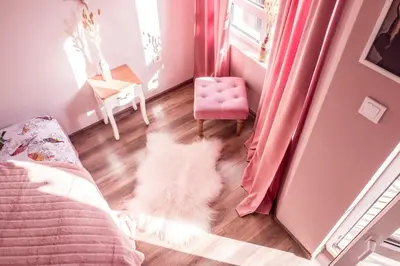 a white dog laying on the floor in a bedroom at Baba Taki Apartment in Plovdiv