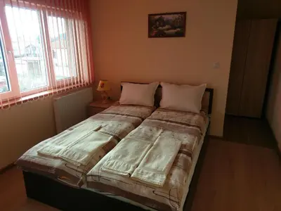 a bedroom with a large bed with two pillows at Стаи за гости Елени in Shiroki Dol