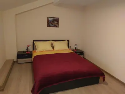 a bedroom with a bed and two night stands at Стаи за гости Елени in Shiroki Dol