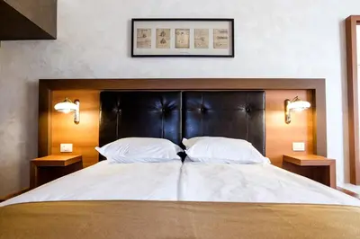 a large bed with two white pillows and two lamps at Hotel Elit in Pernik