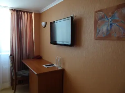 a hotel room with a flat screen tv on the wall at Hotel Elit in Pernik