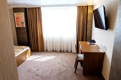 a room with a desk and a bed and a window at Hotel Elit in Pernik