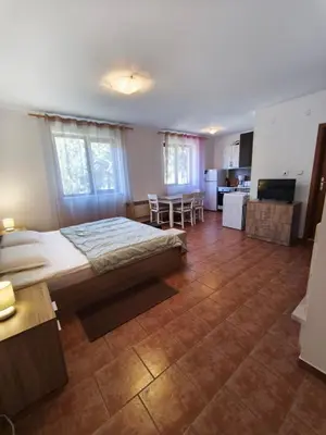 a bedroom with a large bed and a kitchen at the old inn in Bansko