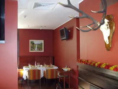 a restaurant with two tables and a deer head on the wall at Kokoshkovata Boutique House in Samokov