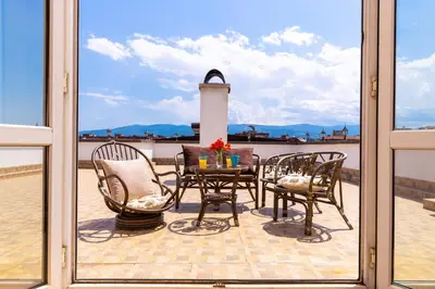 a patio with a table and chairs on a balcony at Roof top terrace maisonette in Plovdiv