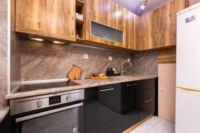 a kitchen with wooden cabinets and a sink at Roof top terrace maisonette in Plovdiv