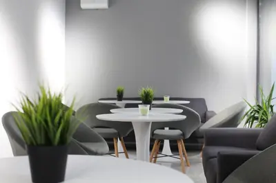 a meeting room with tables and chairs and plants at Hotel39 in Plovdiv