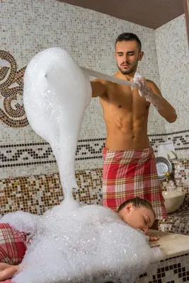 a man in a bathtub making a swan at Apartments Bansko in Bansko