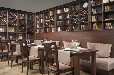 a dining room with tables and chairs and bookshelves at Apartments Bansko in Bansko