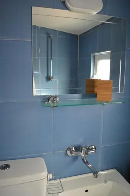 a blue tiled bathroom with a sink and a mirror at Mansard Art Studio - Central Sofia in Sofia