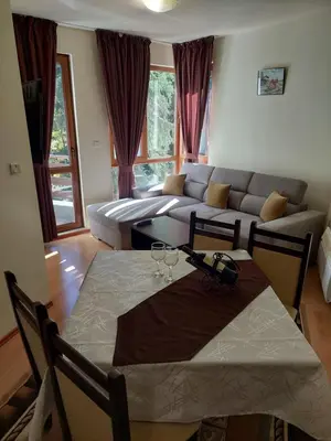 a living room with a table and a couch at Ski & Holiday Apartments in Pamporovo in Pamporovo