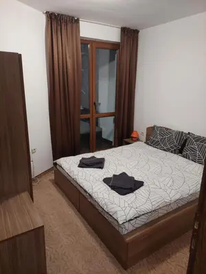 a bedroom with a bed with black towels on it at Ski & Holiday Apartments in Pamporovo in Pamporovo