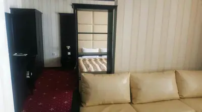 a couch in a room with a bed and a mirror at Hotel Villa Ofir in Sandanski