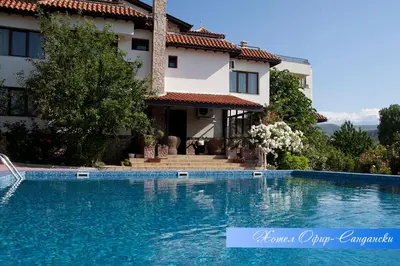 a villa with a swimming pool in front of a house at Hotel Villa Ofir in Sandanski