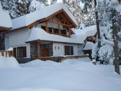 a house covered in snow in the woods at Saint George Holiday Village in Borovets