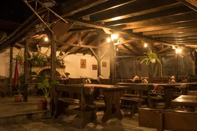a restaurant with wooden tables and chairs and lights at комплекс ВОДОПАДА in Plovdiv