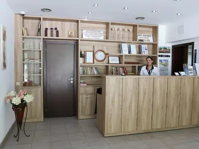 a woman is standing at a counter in a salon at Хотел Аква Варвара in Varvara