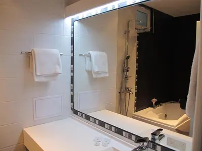 a bathroom with a large mirror and a sink at Хотел Аква Варвара in Varvara