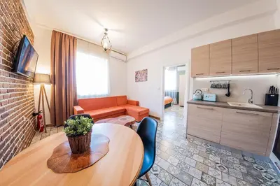 a living room with a table and a kitchen at Sofia Vintage Life Apartment in Sofia