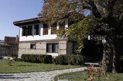 a house with a tree in front of it at Djudjeva Kyshta Hotel in Panagyurishte
