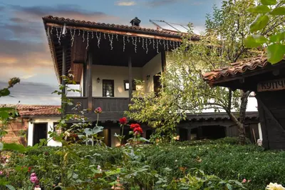 a garden in front of a house with flowers at Djudjeva Kyshta Hotel in Panagyurishte