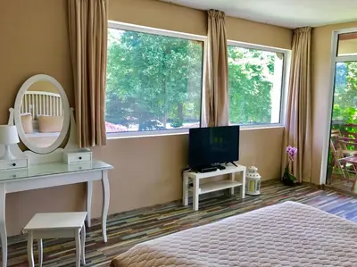 a bedroom with a bed and a mirror and a television at Yaev Family Hotel in Karlovo